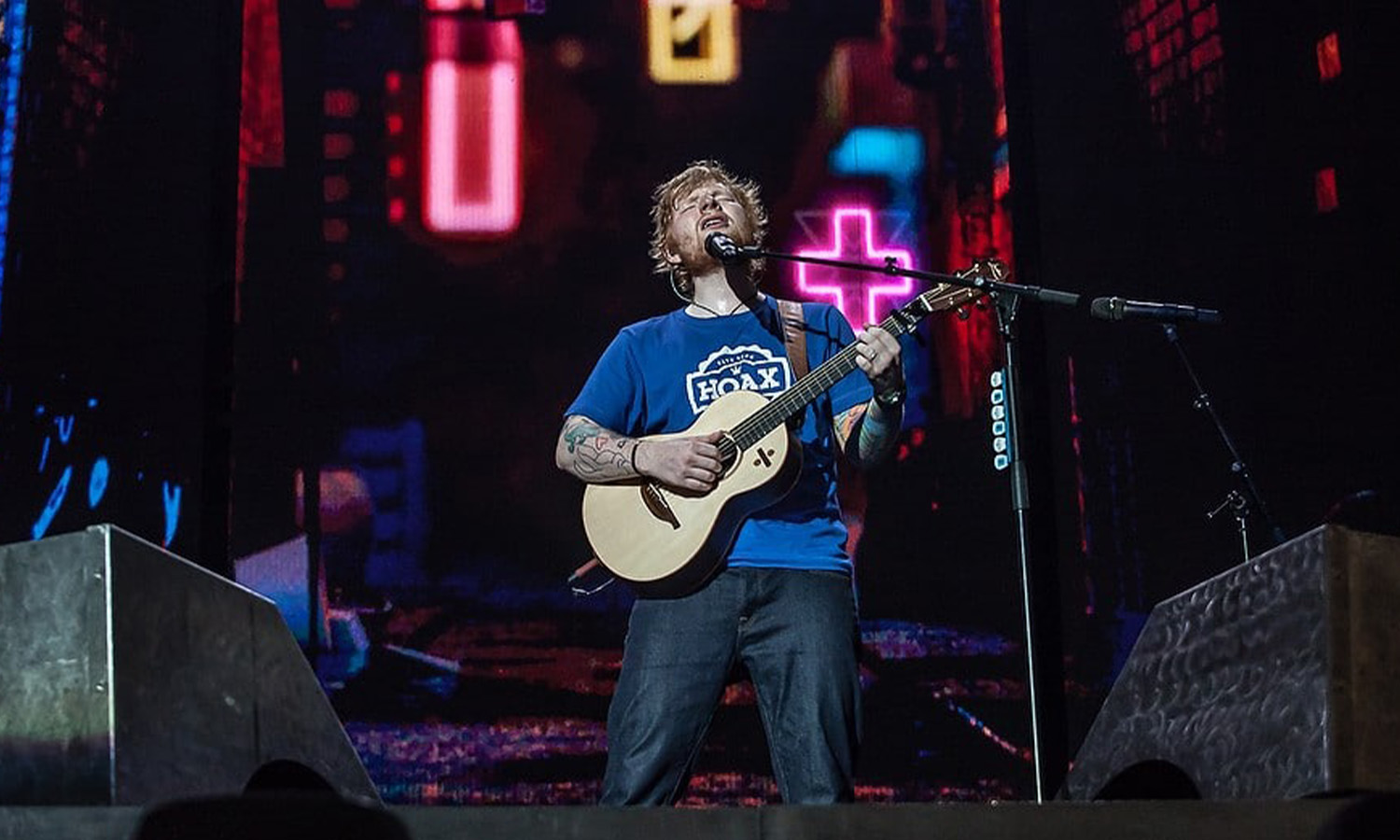 Ed Sheeran steht ganz allein mit seiner Akustikgitarre auf der riesigen Bühne der Veltins-Arena in Gelsenkirchen vor ausverkauftem Publikum.