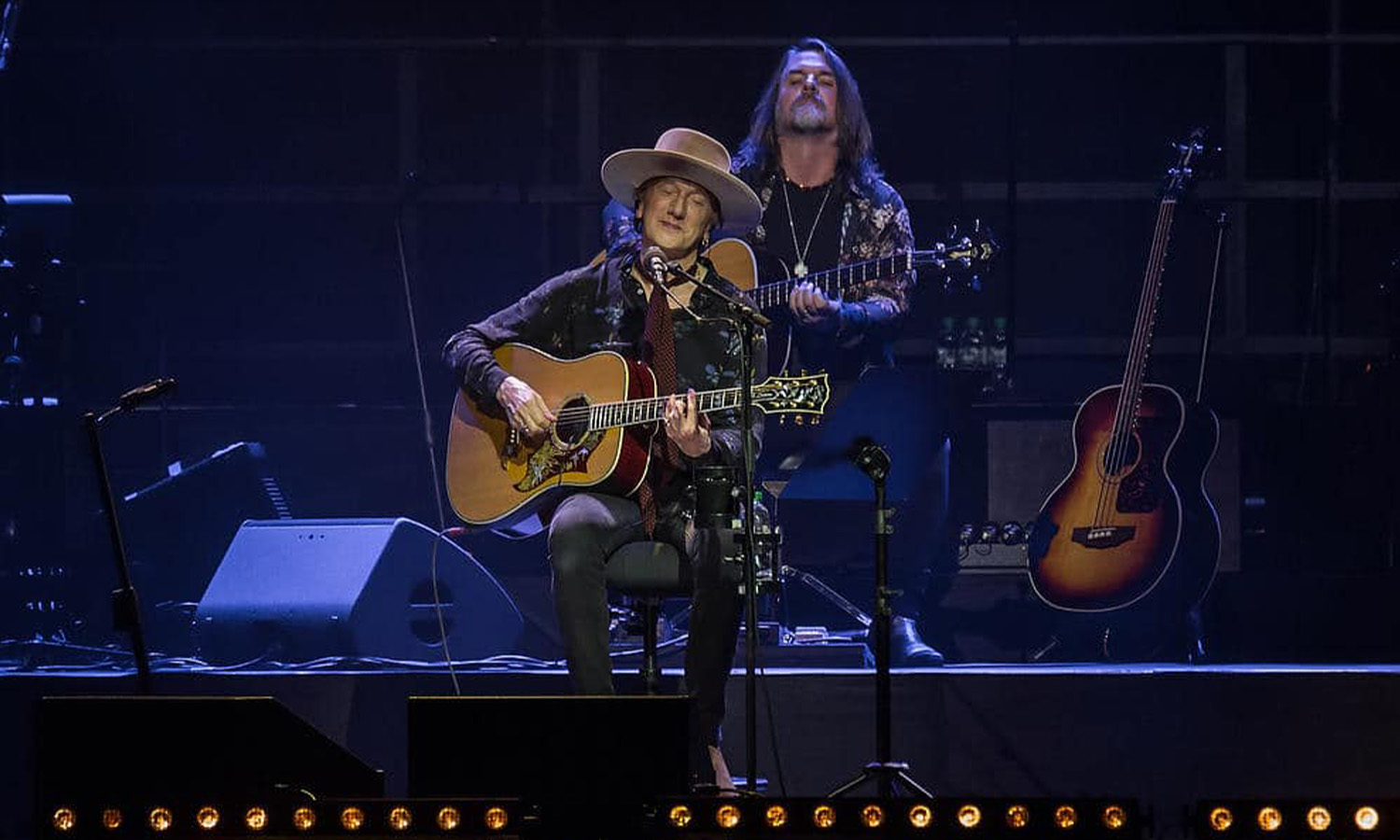 Marius Müller-Westernhagen steht live mit seiner Band auf der Open-Air-Bühne der Loreley vor begeistertem Publikum und malerischer Rhein-Kulisse.