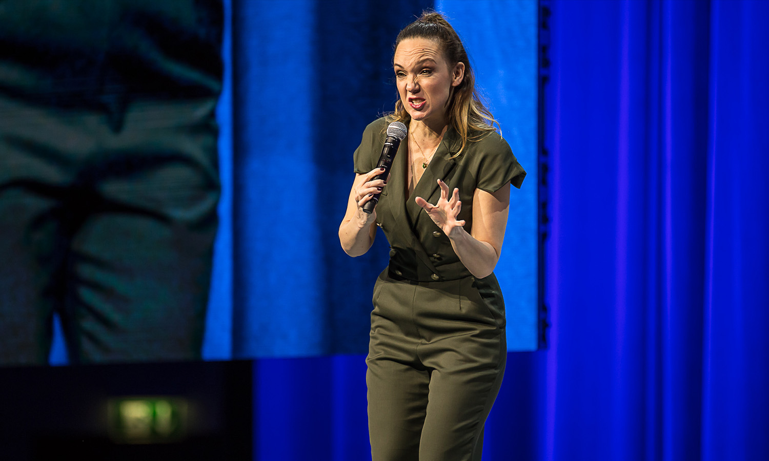 Carolin Kebekus steht gut gelaunt auf der Bühne der Rittal Arena Wetzlar und präsentiert ihr Comedy-Programm PussyNation.