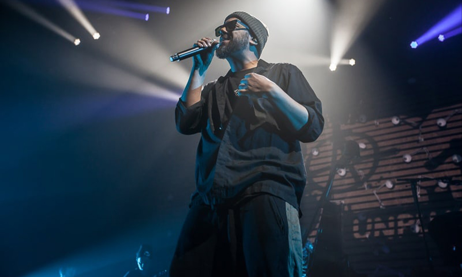 Rapper Samy Deluxe performt voller Energie am Mikrofon auf der Bühne im Schlachthof Wiesbaden.