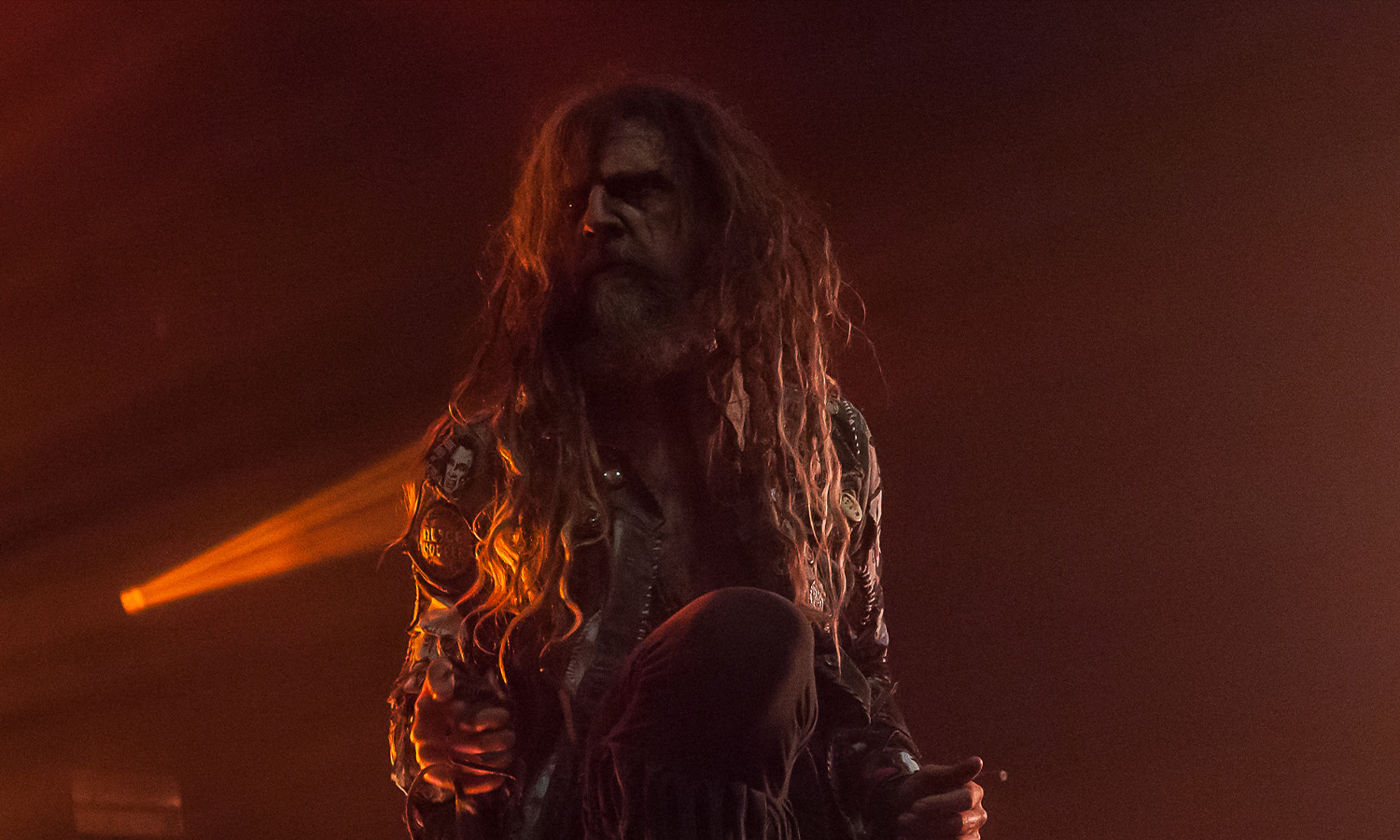Rob Zombie steht mit Mikrofon und markanter Bühnenkleidung auf der farbenfroh beleuchteten Bühne im Schlachthof Wiesbaden.