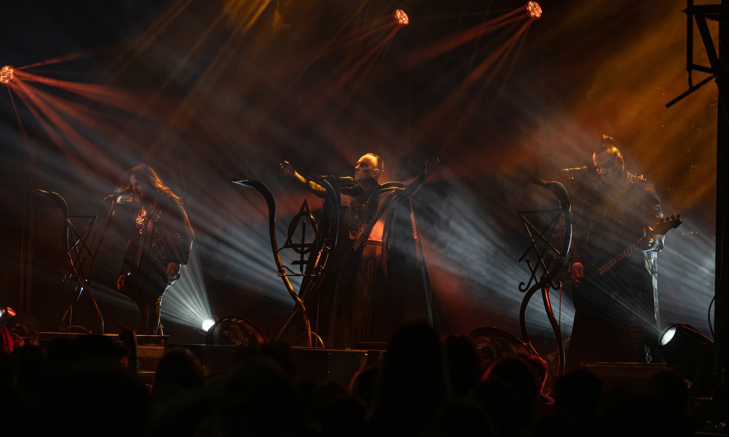 Die Extreme-Metal-Band Behemoth performt am 16. April 2025 live auf der abgedunkelten Bühne des Schlachthofs Wiesbaden unter dramatischem, rotem Bühnenlicht.
